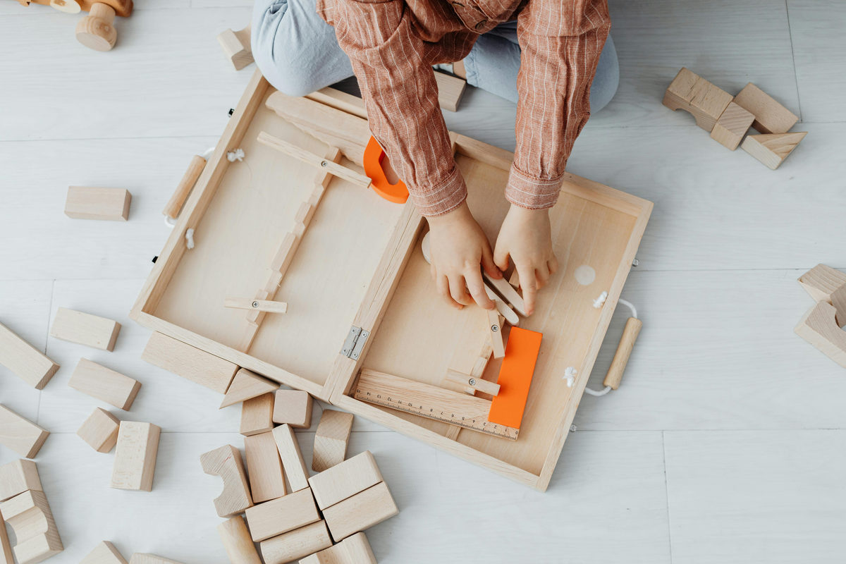 Child playing with wooden blocks and toy tools