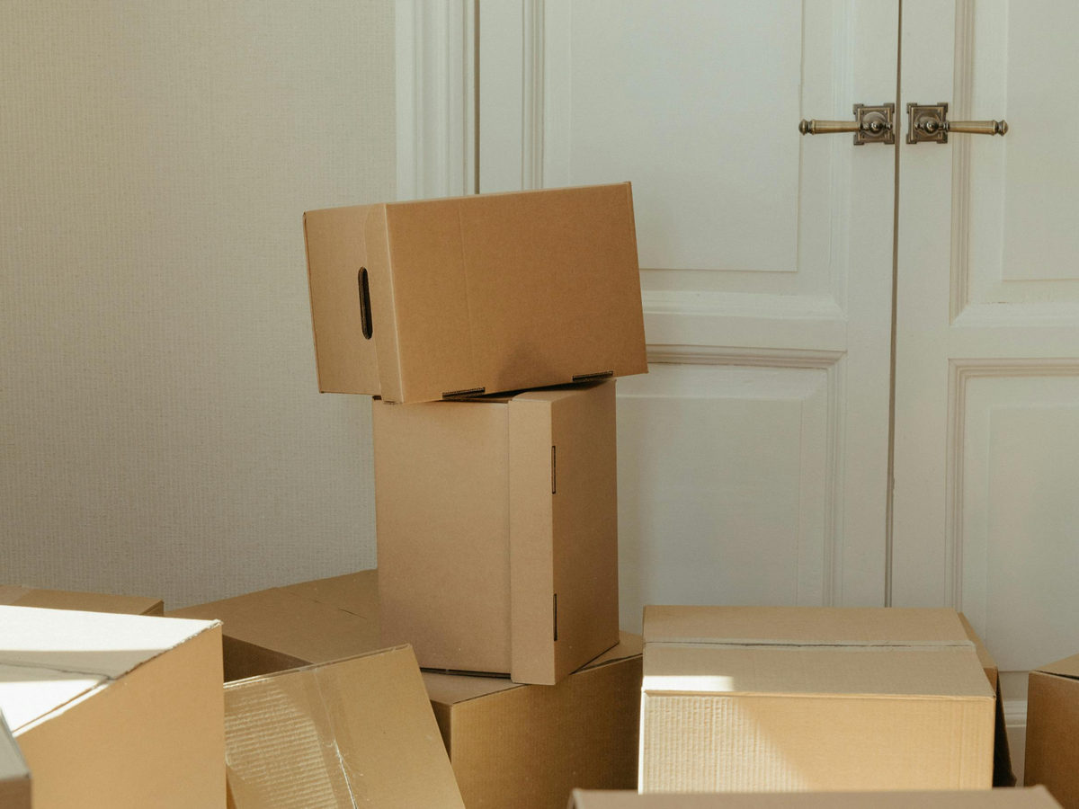 Stacked cardboard moving boxes beside a doorway