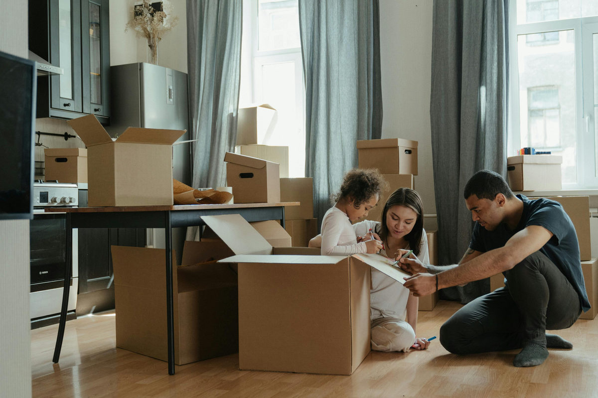 Adults and a child unpacking boxes in a home.