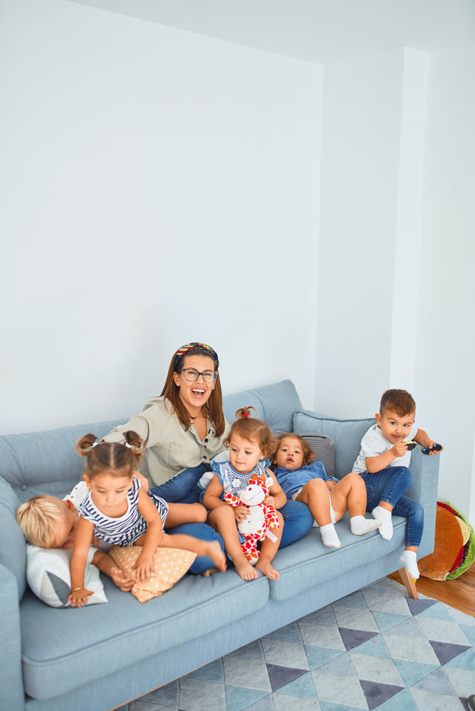 Adults and children sitting together on a sofa.