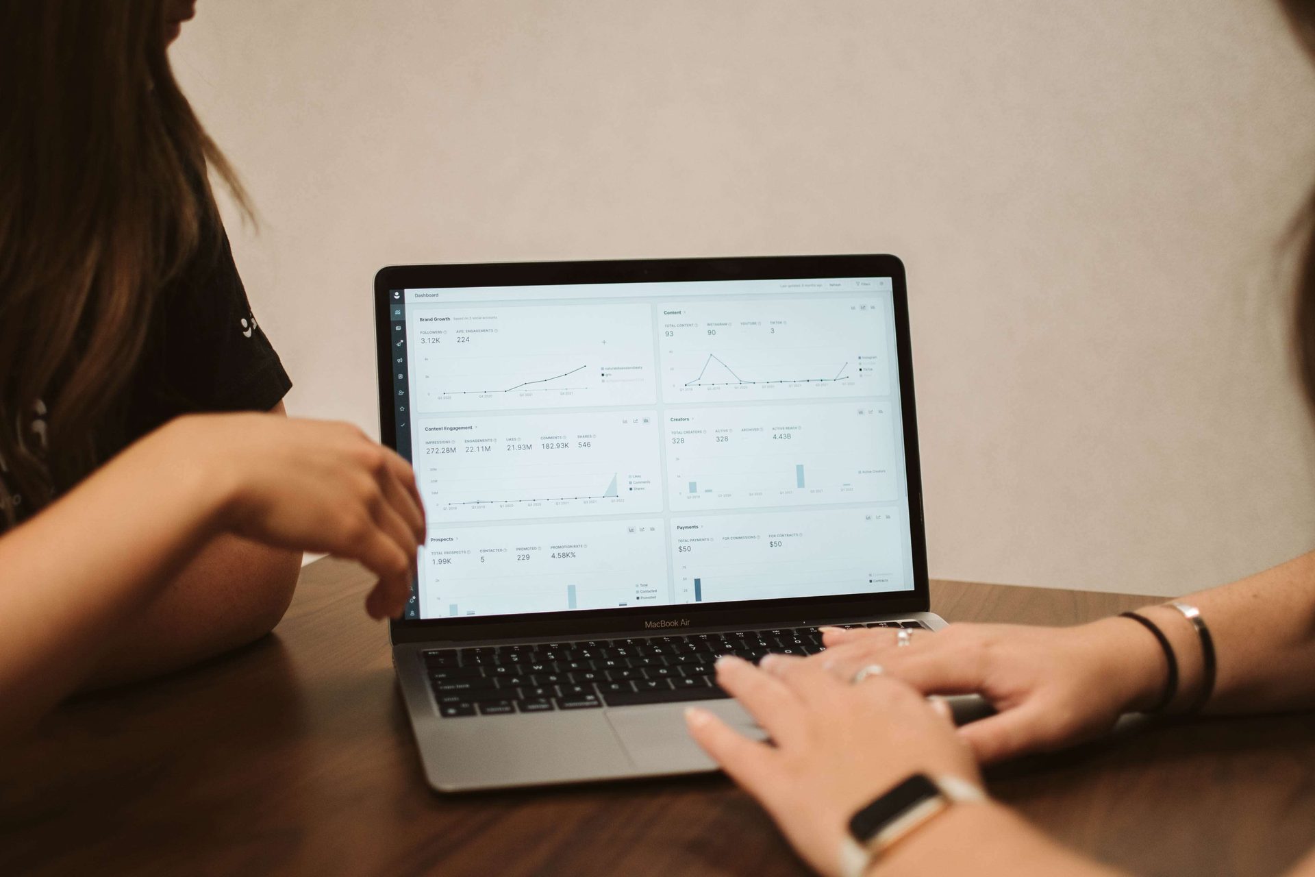 two people writing a report on a computer